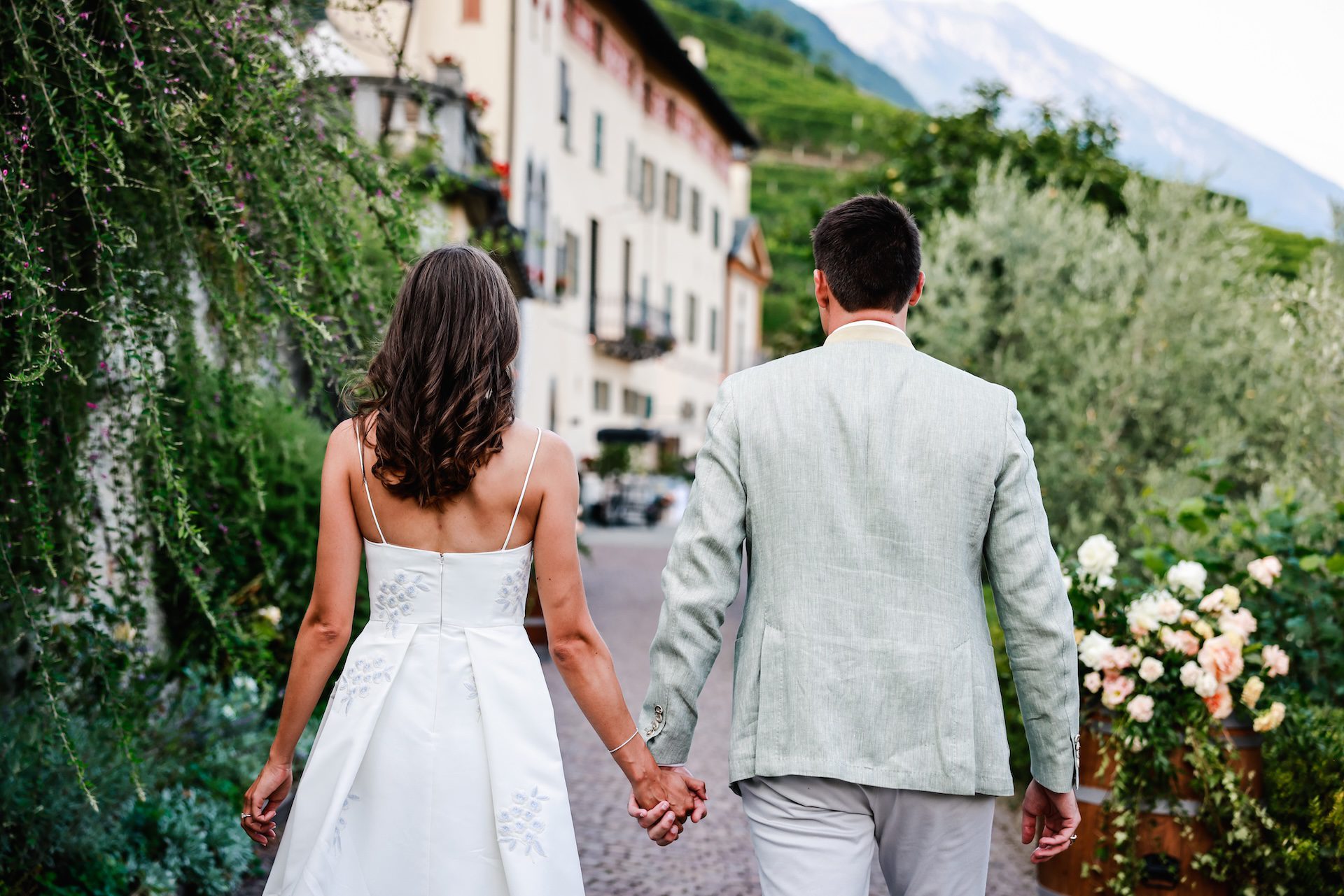 Coppia di spalle che cammina mano nella mano