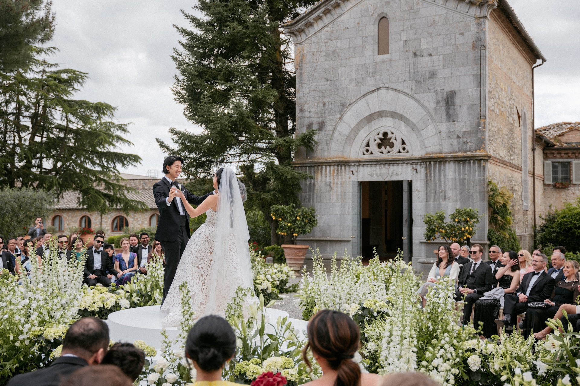 Coppia di sposi durante la cerimonia simbolica organizzata con allestimento circolare di sedie e invitati