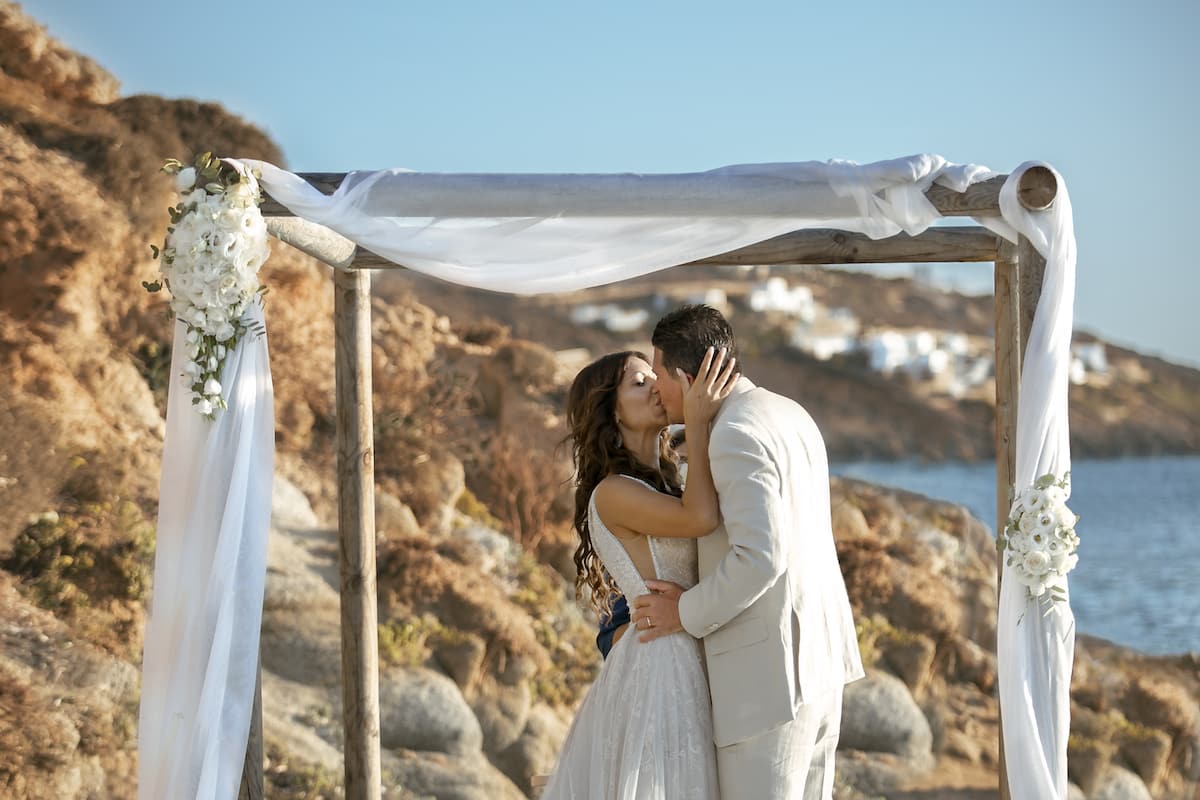 Bacio degli sposi per Destination wedding da sogno sulle spiagge di Mykonos