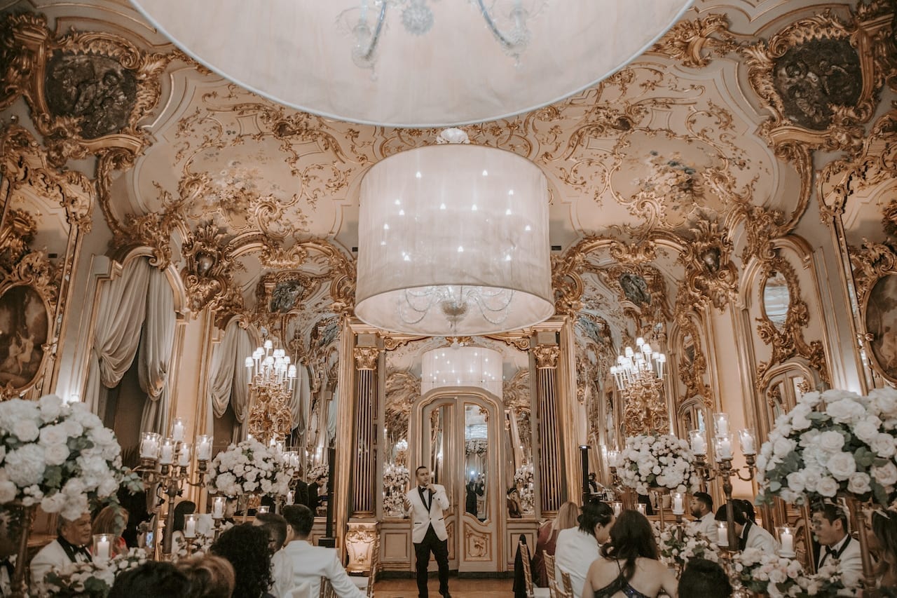 Sposo parla durante il ricevimento nella galleria dorata di Villa Cora