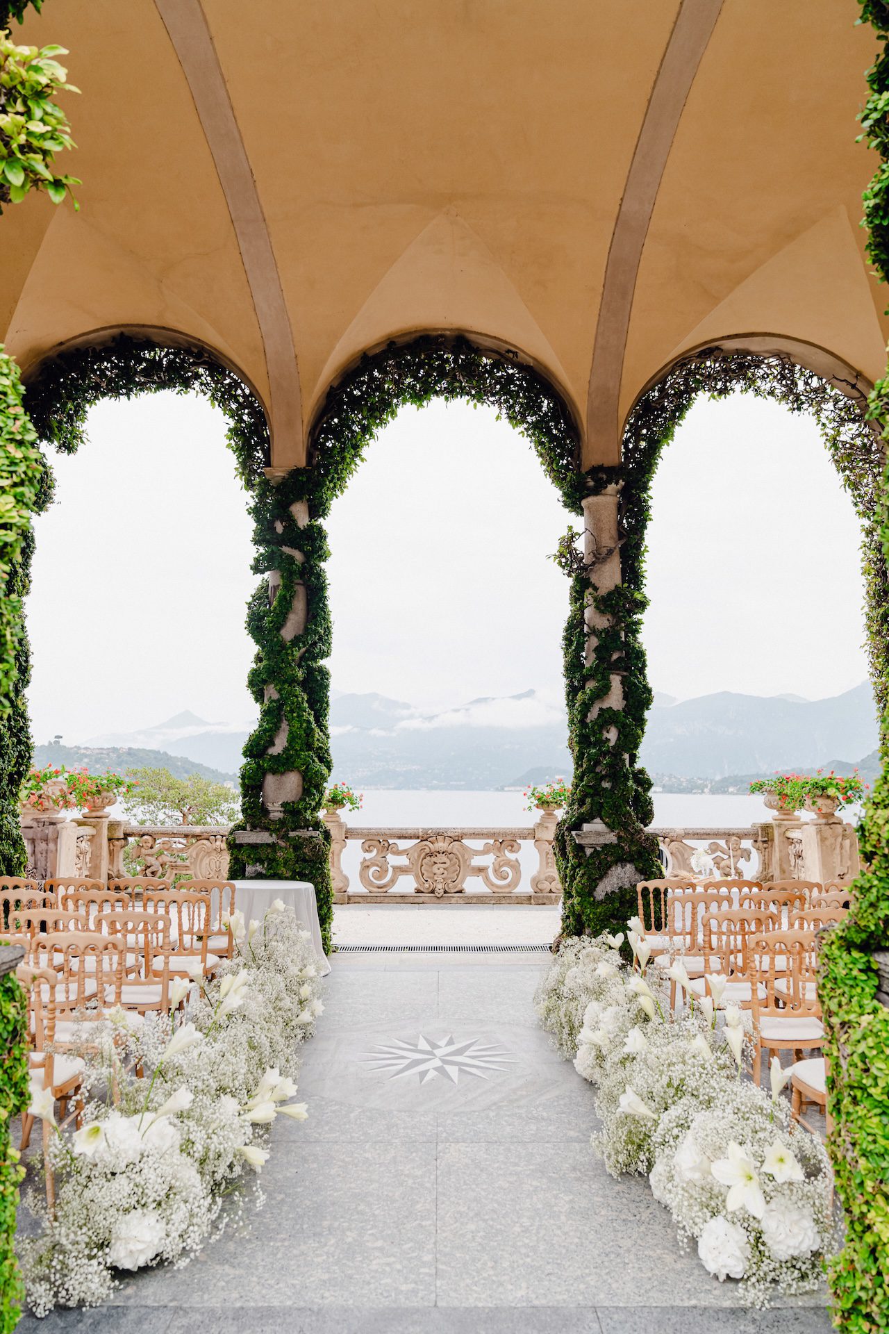 Dettaglio di una location per matrimoni sul Lago di Como con archi rivestiti con fiori e decorazioni naturali